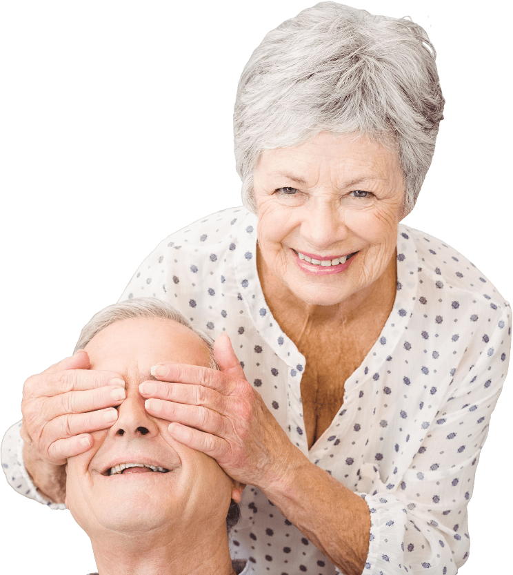 A smiling woman covering her husbands eyes playfully A smiling woman covering her husbands eyes playfully