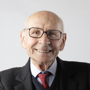 A very happy older man wearing a suit who is happy because Real Life Care won his health care funding case A very happy older man wearing a suit who is happy because Real Life Care won his health care funding case